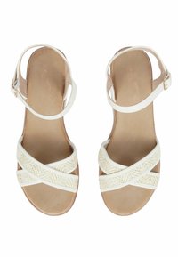 Sandal bianca con cinturini intrecciati incrociati, suola liscia e fibbia alla caviglia. Tessuto morbido e plantare color beige chiaro. Design semplice, stile open-toe.