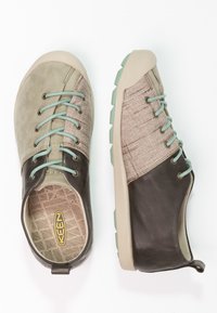 Dvoje bot KEEN v zelené, béžové a tmavě hnědé barvě. Mají texturovanou tkaninu, hladkou kůži a mátové tkaničky, s polstrovanou stélkou a flexibilní podrážkou.