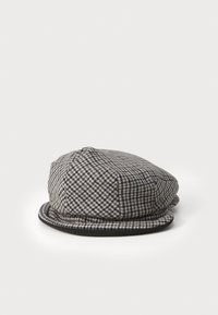 Grå og sort houndstooth-mønstret hat med en rund krone og en flad skygge, der har en mørk kant langs bunden.