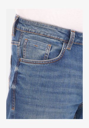 Lichtblauwe denimjeans met een klassiek vijfzakkenontwerp, zichtbare oranje stiksels en een recht model.