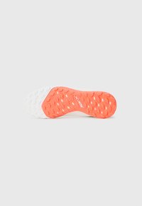 Shoe sole features a textured design with a white and vibrant orange color scheme, displaying circular traction points and branding.