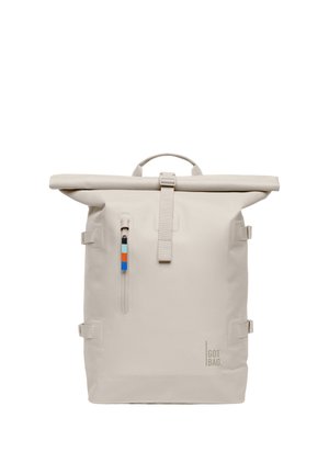 Zaino beige con chiusura a rotolo, tasca frontale con cerniera verticale, tiretto della cerniera bicolore, cinturini laterali di compressione e logo "GOT BAG" in basso a destra.