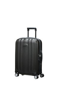 Black hardshell suitcase with vertical ribbed design, retractable handle, and four wheels for maneuverability. Features a combination lock.