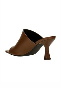 Mules à talons ouverts en cuir marron avec un talon sculpté et angulaire et une surface lisse. Présentent un design minimaliste avec une texture douce.