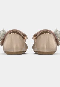 Ξανθά μπαλέτα παπούτσια με απαλή, γυαλιστερή επιφάνεια, μαλακή άκρη και διακοσμητικό λουλούδι στο πλάι. Επίπεδη σόλα από καουτσούκ.