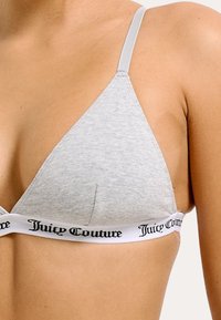 Grijze katoenen triangle bralette met dunne bandjes en elastische band met zwart "Juicy Couture" logo; gladde textuur, minimalistisch ontwerp.