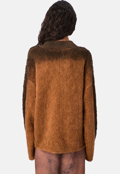 Brązowy, oversize sweter z teksturowanego, puszystego materiału. Posiada ciemnobrązowy gradient na ramionach oraz ściągacz przy kołnierzu.