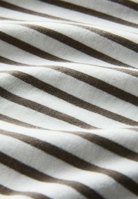 Tela suave con rayas horizontales blancas y marrones, mostrada en primer plano con textura visible y sombras ligeras.