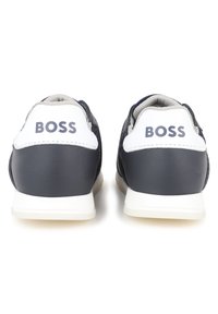 Navy sneakers with white accents, leather upper, padded collar, and rubber sole. “BOSS” logo on the heel. Smooth and textured surfaces.