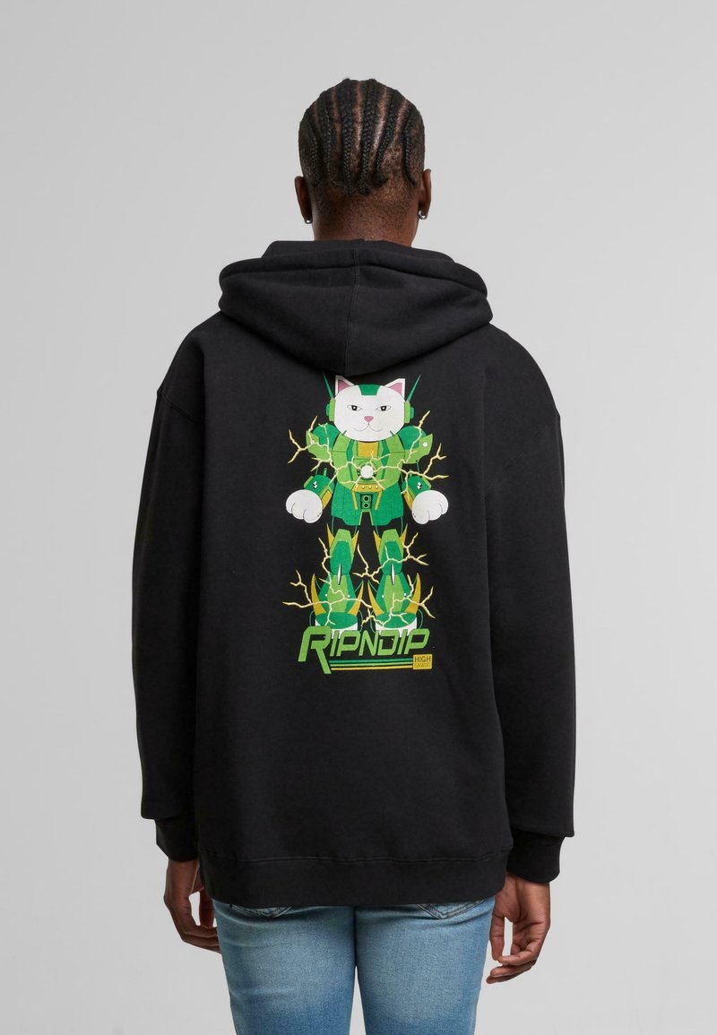 Persona con capelli intrecciati che indossa un hoodie nero con un gatto robotico verde con fulmini gialli e la scritta "RIPNDIP" sulla parte posteriore.
