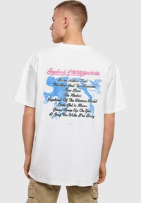 Balta per didelė t-shirt maika, ant nugaros esanti spalvinga tekstūra ir grafikomis, su frazėmis rožine ir juoda spalvomis, bei mėlynais akcentais.