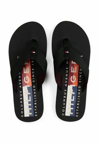 Infradito nere con cinturini in tessuto, caratterizzate da un logo e un design testuale in bianco, rosso e blu sulla soletta. Suola piatta.