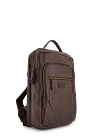 Bruine leren rugzak met dubbele voorritsen, een handvat aan de bovenkant en verstelbare schouderbanden. Gelaagd oppervlak met subtiele markeringen.