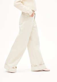 Brede beige broeken van zachte denim met een hoge taille, met een opgerolde zoom en zakken aan de achterkant.