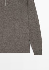 Maglione marrone a maglia con colletto a zip a quarto e maniche lunghe, caratterizzato da polsini e orlo a coste.