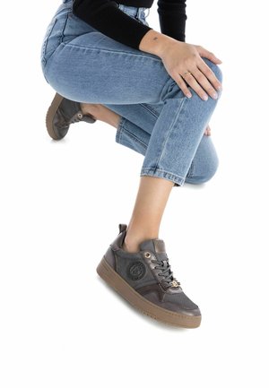 Zapatillas grises con una parte superior texturada, suela de goma y logotipo en relieve. Cintas y una etiqueta trasera para facilitar su uso. Diseño de perfil bajo.