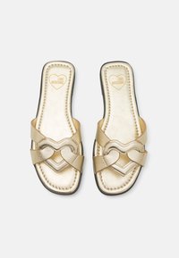 Auksinės šlepetės su širdelės formos dirželiais, dirbtinės odos tekstūra, paminkštintas padas ir juodas padas. Išgraviruota "LOVE MOSCHINO" ant vidpadžio.