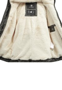 Black outer jacket with a soft beige fur lining; features a label on the inside with brand details and a pocket for headphones.