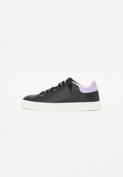 Black leather sneaker with a white rubber sole, featuring black laces, silver eyelets, and a light purple accent at the heel.