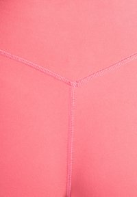 Roze aansluitende stof met een V-vormige naad en een gladde textuur, met contrasterende stikseldetails langs de randen.