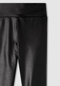 Leggings neri realizzati in un tessuto liscio e lucido, con un ampio elastico in vita, caratterizzati da un design aderente e senza cuciture o motivi visibili.