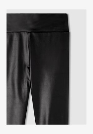 Leggings neri realizzati in un tessuto liscio e lucido, con un ampio elastico in vita, caratterizzati da un design aderente e senza cuciture o motivi visibili.