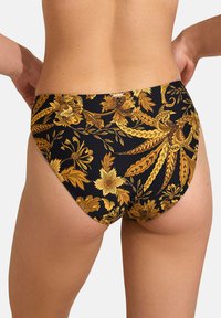 Bas de bikini noir avec un motif floral doré, doté d'une texture lisse et d'un design échancré. Étiquette de marque métallique visible à l'arrière.