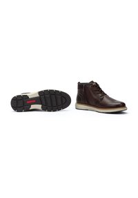 Brown leather ankle boots with lace-up front and side zipper. Rubber outsole with textured tread pattern, contrasting ivory midsole.