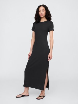 Robe maxi noire à manches courtes en tissu doux ; dotée d'une fente latérale et d'un col rond, assortie à des tongs noires.