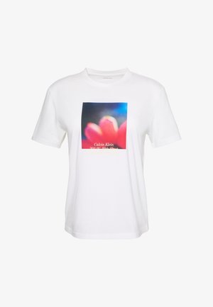 T-shirt blanc à manches courtes avec un graphisme flou de fleur rouge et un texte partiel Calvin Klein au centre devant.