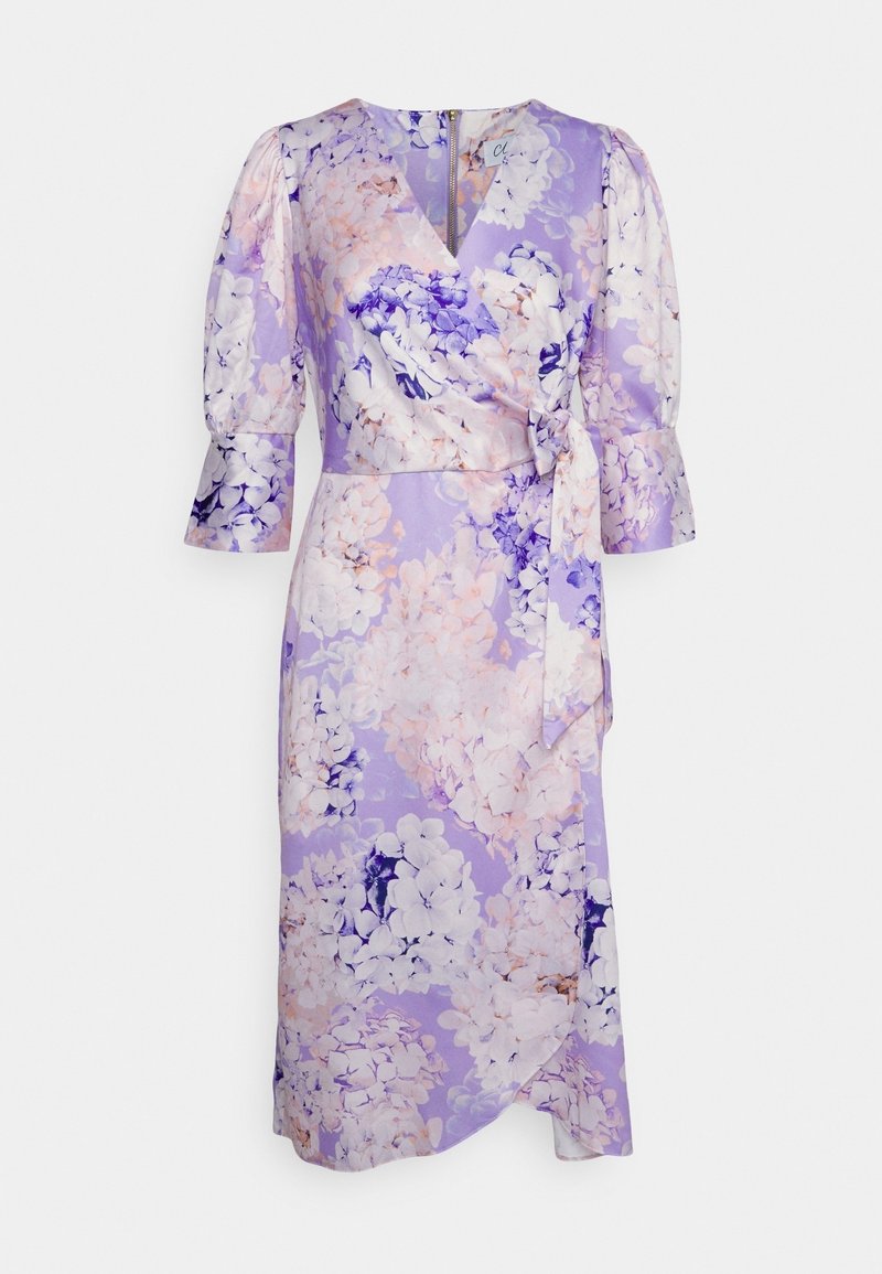Robe portefeuille violette avec imprimé floral rose et blanc, manches ballon trois-quarts, encolure en V et lien de taille côté.