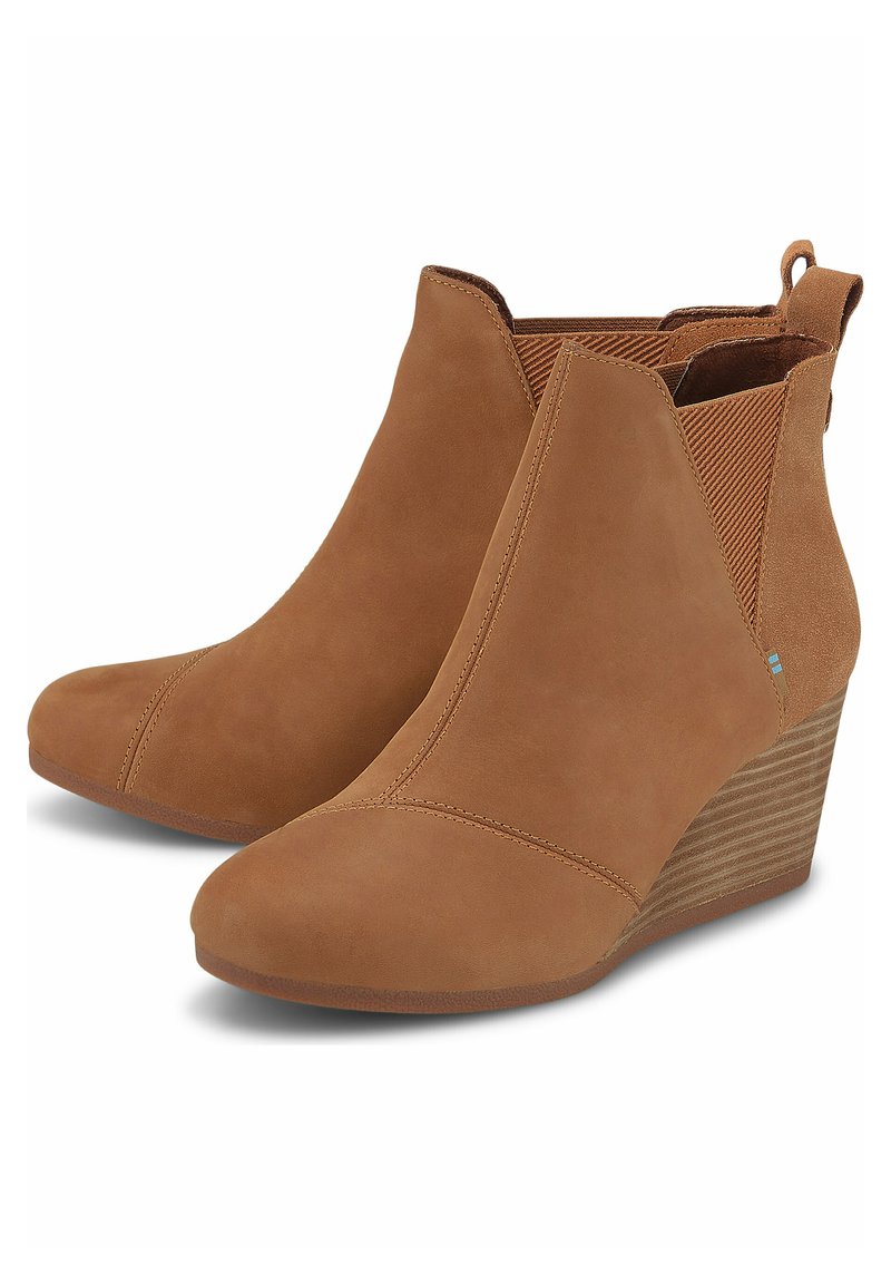 Botines de tobillo marrones con cuña, hechos de ante, que presentan paneles laterales elásticos, textura suave, punta afilada y un tacón de cuña a rayas.