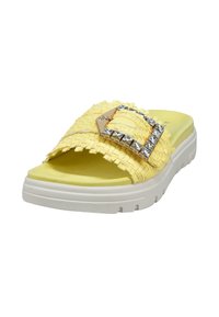 Zueco amarillo tejido con una tira texturizada, hebilla adornada con gemas transparentes y suela blanca.