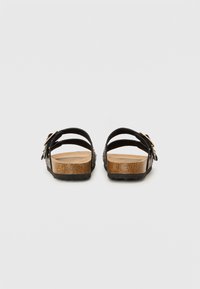 Sandales en cuir noir avec deux straps ajustables, semelle en liège, semelle en bois et semelle extérieure en caoutchouc pour une meilleure adhérence. Design minimaliste, sans motifs.