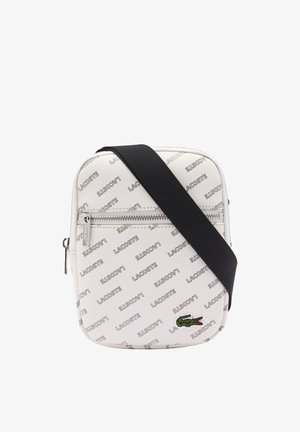 Weiße Lacoste Umhängetasche mit wiederholtem Logomuster, grünem Krokodil-Emblem, vorderer Reißverschlusstasche und schwarzem verstellbarem Schulterriemen.