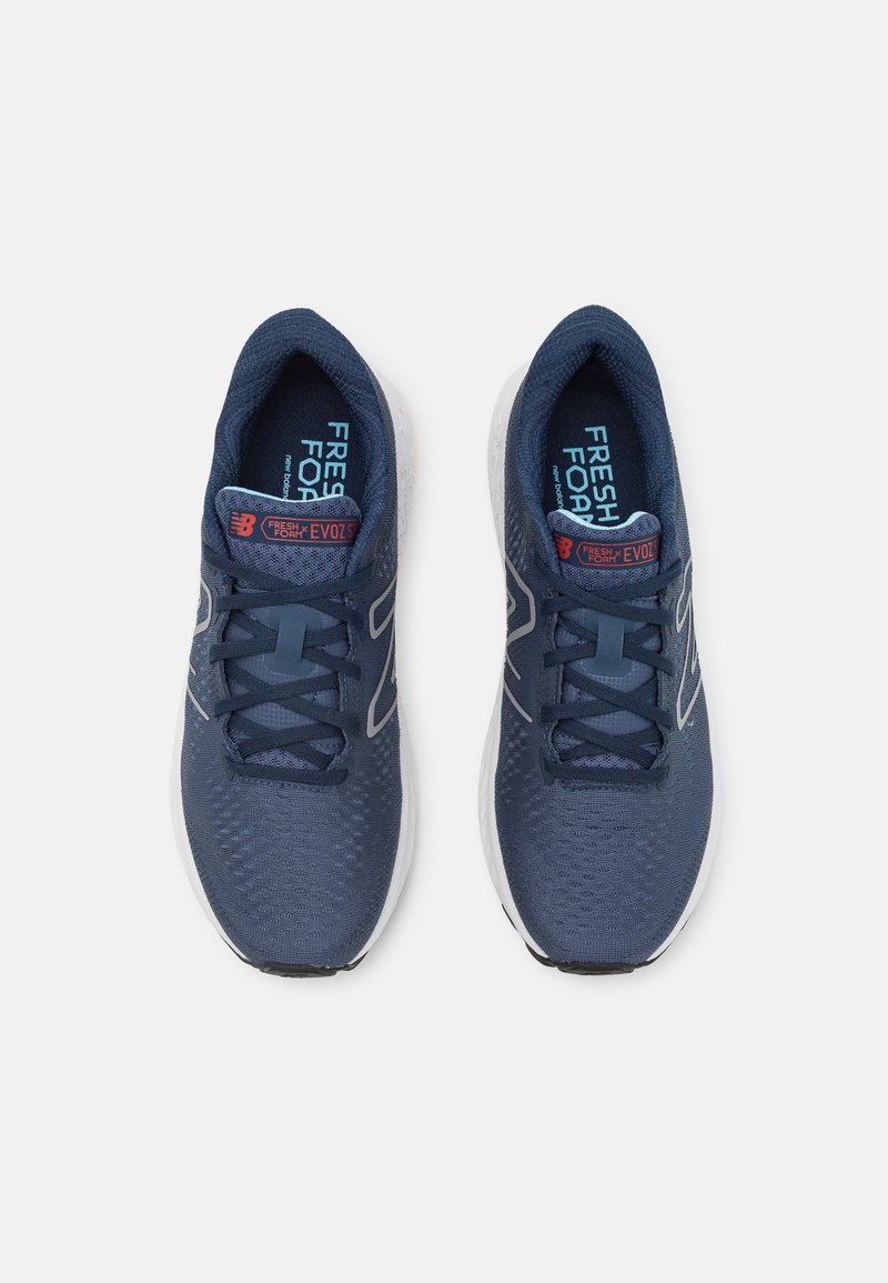 Dunkelblaue Sportschuhe mit einem oberen Teil aus Netzmaterial, strukturiertem Design, weißer Zwischensohle und schwarzer Laufsohle. Verfügt über eine Schnürung und Branding auf der Zunge.