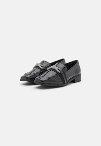 Mocassins en cuir verni noir avec un petit talon bloc, dotés d'un accent décoratif en corde argentée et d'un design élégant à bout pointu.