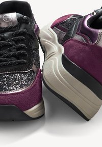 Sneaker in camoscio viola e glitter neri con accenti riflettenti, dettagli testurizzati e una suola spessa e ammortizzata per il supporto.