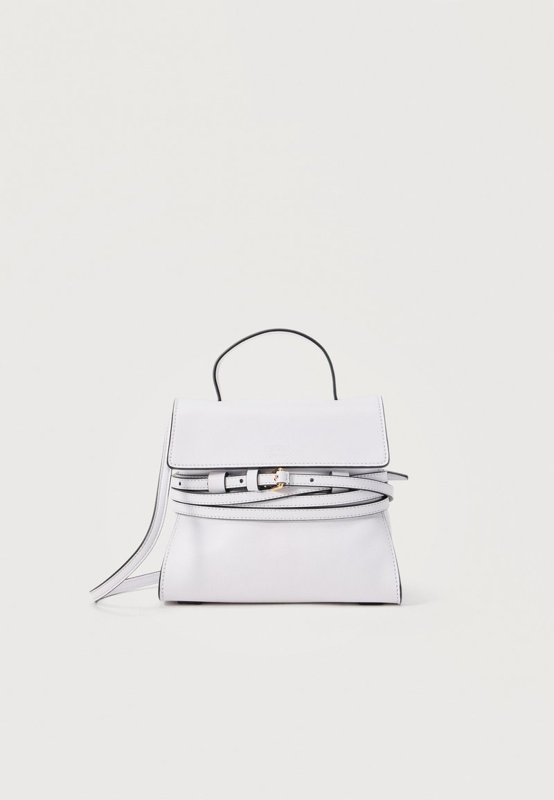 Λευκή δερμάτινη τσάντα χειρός με πάνω λαβή, μπροστινό καπάκι και λεπτή, ρυθμιζόμενη ζώνη σε απλό ανοιχτό φόντο.