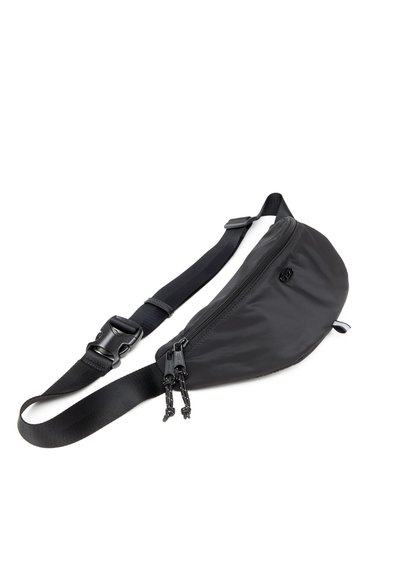 Sac banane noir en nylon avec une forme arrondie, doté d'une fermeture éclair à l'avant, d'une sangle réglable et d'une fermeture en plastique.