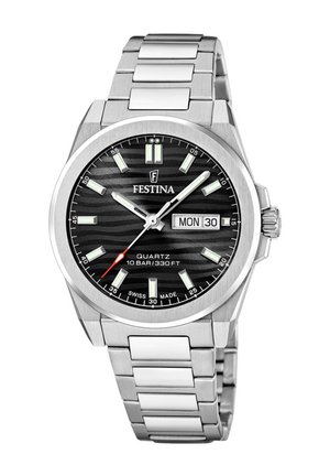 Montre en acier inoxydable argenté avec un cadran noir à rayures, des index d'heure lumineux, un affichage de la date et un accent rouge sur la seconde.