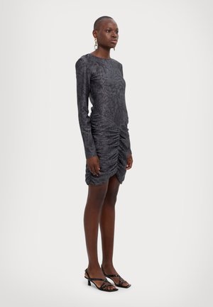 Dark gray long-sleeve dress with textured fabric, ruched detailing at the waist, and knee-length hem. Paired with strappy black heels.