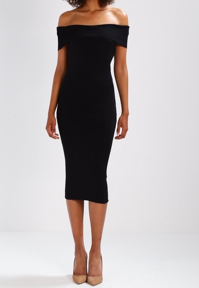 Robe midi noire à épaules dénudées en tissu extensible, présentant une silhouette ajustée et une texture lisse. Portée avec des escarpins nude.