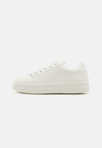 Baskets blanches avec une tige en cuir lisse, bout rond et un accent en maille texturée au niveau du talon. Elles présentent des lacets plats et une semelle en caoutchouc épaisse.