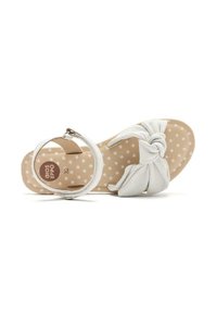 Sandal bianco con design a cinturino annodato, fibbia circolare alla caviglia e soletta beige decorata con piccole stelle bianche. Suola piatta, materiale sintetico.