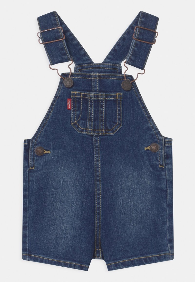 Salopette courte en jean bleu avec bretelles réglables, poche poitrine avant, boutons latéraux et surpiqûres jaunes contrastées.