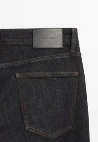 Mörk tvättade denimjeans med en svart läderetikett präglad med "Massimo Dutti" i midjan. Har kontrasterande sömmar och bakfickor.