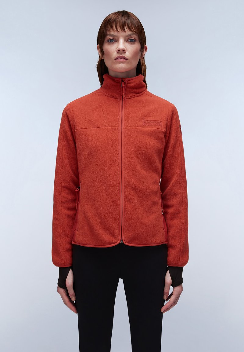 Giacca in pile arancione scuro con colletto alto, zip frontale e tasche laterali. Presenta cuciture a contrasto e un logo sul petto.