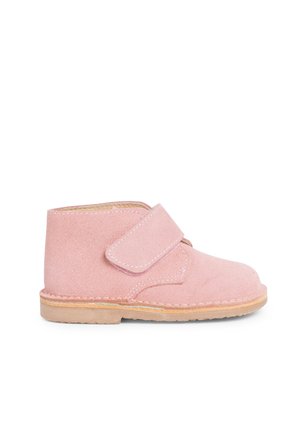 Roze suède enkellaars met een klittenbandsluiting, beige zool, ronde neus en gestikte details langs de zool. Zachte textuur met een minimalistisch ontwerp.
