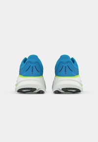 Um par de sapatos atléticos azuis com solas brancas e piso preto, vistos pela parte de trás; texto "BONDI 9" visível em cada calcanhar.
